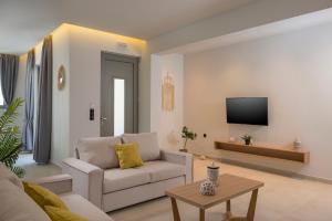 马莱迈Aegean Breeze Luxury Apartments的带沙发和电视的客厅