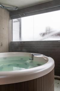 鲁卡Ski-Inn RukaValley的带窗户的浴室设有大浴缸