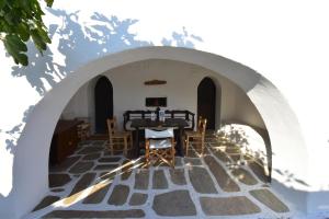 伊奥斯乔拉Petra Holiday Village的拱门下方的桌椅