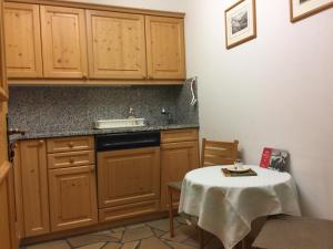 达沃斯2-Zimmer Ferienwohnung Bünda的厨房配有一张桌子,上面有白色的桌布