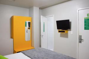 里约热内卢伊帕内玛切拉加图旅馆的卧室配有一张床,墙上配有电视。