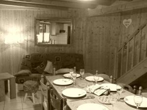 雷加霍斯达哈施Demi-Chalet l'Ancolie -- Prox pistes的用餐室配有带盘子和酒杯的桌子