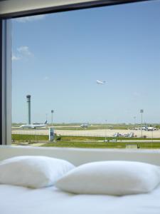 鲁瓦西昂法兰西巴黎戴高乐机场世民酒店 的透过窗户可欣赏到机场跑道的景色