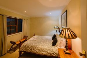 格洛斯特Barrington Hideaway- River Cottages的一间卧室配有一张床和一张桌子上的两盏灯。