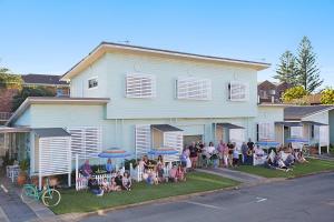 黄金海岸La Costa Beachside Motel的一群坐在房子前面的人