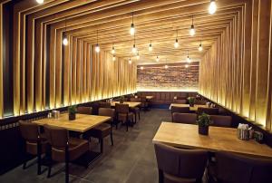 多尼杜纳约维采布拉格餐厅旅馆的餐厅拥有木墙和桌椅