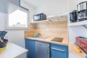 鲁瓦扬Le coeur de Royan studio 2 étoiles的一间小厨房,内配蓝色橱柜和水槽