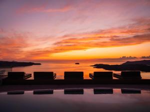 费拉Lilium Hotel Santorini的享有日落背景的游泳池