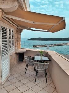 科尔丘拉Apartments Luka, Punta Jurana的阳台的天井配有桌椅