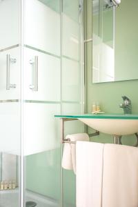 波尔图欧帕多赛文酒店的一间带水槽和玻璃淋浴的浴室