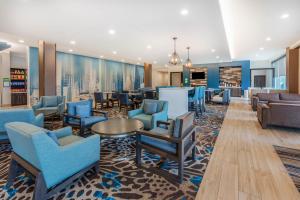 斯普林La Quinta Inn and Suites by Wyndham Houston Spring South的大堂设有蓝色的椅子和桌子。