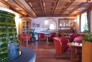 瓦雷纳艾尔皮诺酒店的一间设有红色椅子和桌子的等候室