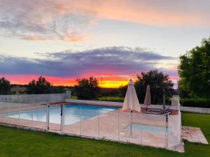 阿尔特杜尚Monte da Boavista - Country family house的一个带两把遮阳伞和日落的游泳池