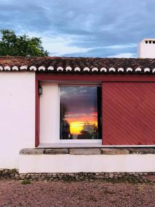 阿尔特杜尚Monte da Boavista - Country family house的红色和白色的房子,设有享有日落美景的窗户