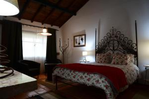 LadoeiroQuinta dos Trevos - Artes e Ofícios的一间卧室配有一张带红色毯子的大床
