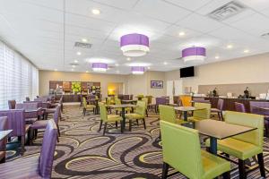 圣安吉洛圣安吉洛会议中心拉昆塔酒店的一间配备有桌椅的用餐室,并拥有紫色和绿色装饰