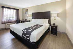 西棕榈滩西棕榈滩 - 佛罗里达收费公路拉金塔酒店的酒店客房设有一张大床和一张书桌。
