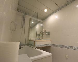 巴黎卢浮宫酒店的白色的浴室设有浴缸和水槽。