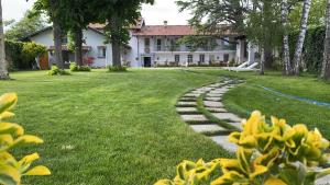 库尼奥ANTICA VILLA - Guest House & Hammam - Servizi come un Hotel a Cuneo的房屋前带石头路的花园