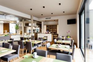 Beringen马萨酒店的一间带桌椅的餐厅和一间厨房