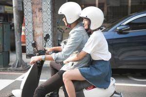 台中市过来旅店的两个戴头盔的女人在街上骑摩托车