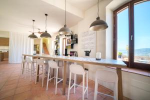 隆达Cortijo LA Organic的厨房设有长条吧台和白色凳子