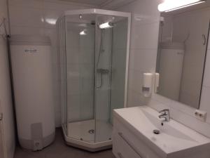 Skudeneshavn尚酷德尼森露营酒店的带淋浴、盥洗盆和镜子的浴室