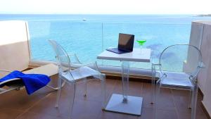 卡法斯Erytha Hotel & Resort Chios的一张桌子和椅子,上面有一台笔记本电脑