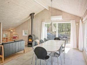 斯皮兹嘉德Four-Bedroom Holiday home in Nexø 14的一间带桌椅和壁炉的用餐室