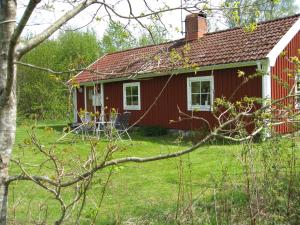 UrshultTildas Urshult的前面有一座绿色庭院的红色房子
