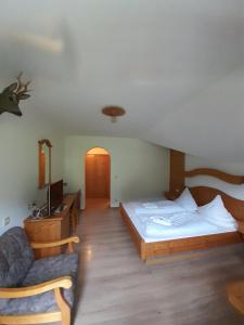 贝希特斯加登玛丽亚格恩宾馆的一间卧室,卧室内配有一张床和一把椅子
