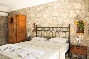 卡亚克多加公寓酒店的一间卧室设有一张床和石墙