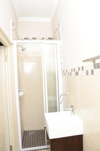 德班莉莉的避风港公寓的带淋浴和白色盥洗盆的浴室