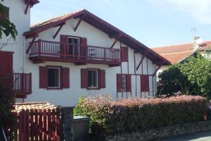 西布勒Chambres d'hôtes Gela Itsasoa Océan的白色的房子,设有红色的阳台和围栏