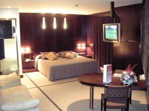奥伦塞弗朗西斯二世酒店的一间卧室配有一张床、一张桌子和一台电视。