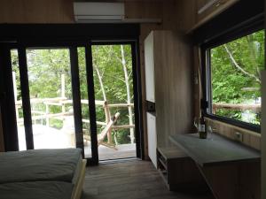阿伊多夫什契纳Small holiday houses的一间卧室设有一张床和一个滑动玻璃门