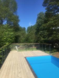 LimerayDomaine de La Clef des Champs的树木繁茂的木甲板上的游泳池