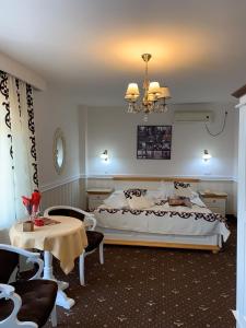 普洛耶什蒂Pensiunea Casa Simoni的一间卧室配有一张大床和一个吊灯。