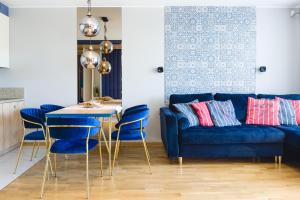 弗瓦迪斯瓦沃沃Klif Residence的客厅配有蓝色的沙发、桌子和椅子