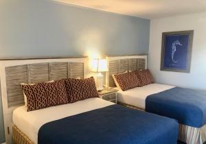 柏斯海滩Beach View Hotel的酒店客房,配有两张带蓝色床单的床