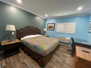 加迪纳市Redondo Beach Motel - LAX的一间卧室设有一张床和蓝色的墙壁