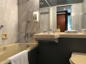 白马村莎士比亚酒店的一间带水槽、浴缸和卫生间的浴室