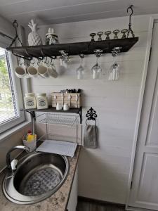 科尔卡Vārpas的厨房配有水槽和带锅碗瓢盆的架子