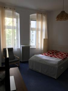 柏林Klein App in Alt - Tegel的一间卧室配有一张床、一把椅子和窗户。