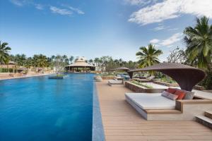 金兰金兰融合度假酒店 - Spa全包的度假村的游泳池配有长椅和遮阳伞