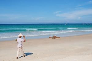 金兰金兰融合度假酒店 - Spa全包的戴帽子在海滩上散步的人
