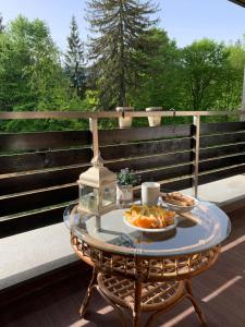 波亚纳布拉索夫TIAM Apartment Poiana Brașov D117, 3 rooms, 3 terraces, 3 bathrooms的甲板上一张桌子,上面放着两盘食物