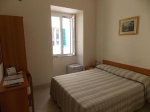 马泰拉罗马阿尔伯格酒店的一间小卧室,配有床和窗户