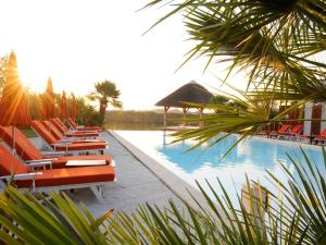圣马迪拉莫埃斯特尔恩卡马格酒店的游泳池旁的一排躺椅