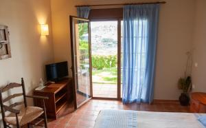 阿尔考辛Hotel Cortijo de Salia的一间卧室配有电视和滑动玻璃门